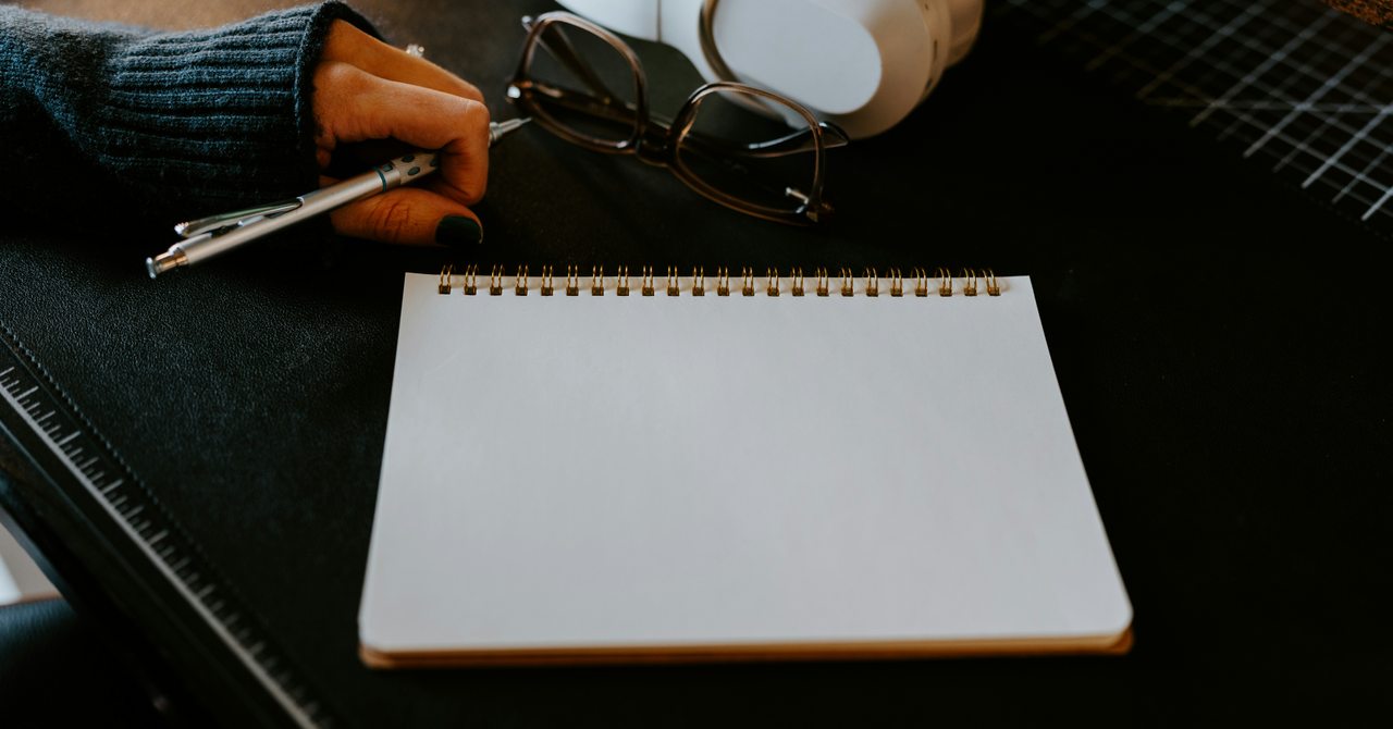 書き出す前のメモ帳とペンが置かれた実写写真